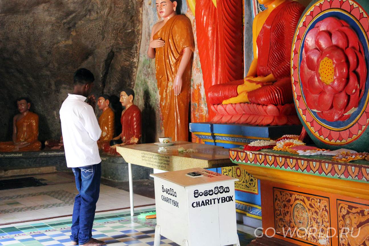 Местный житель молится перед статуей будды.