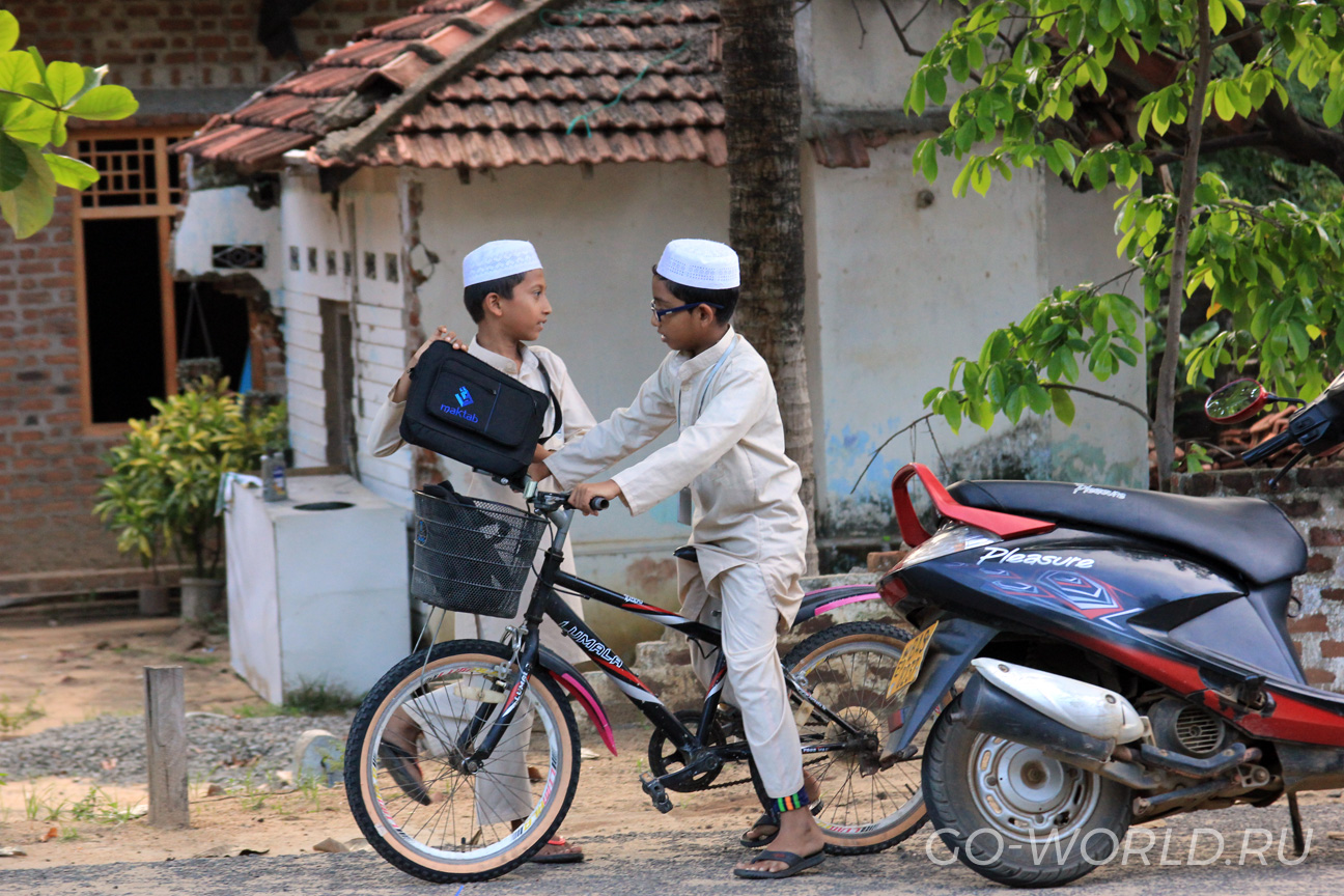Ребёнок на велосипеде собирается домой из школы.